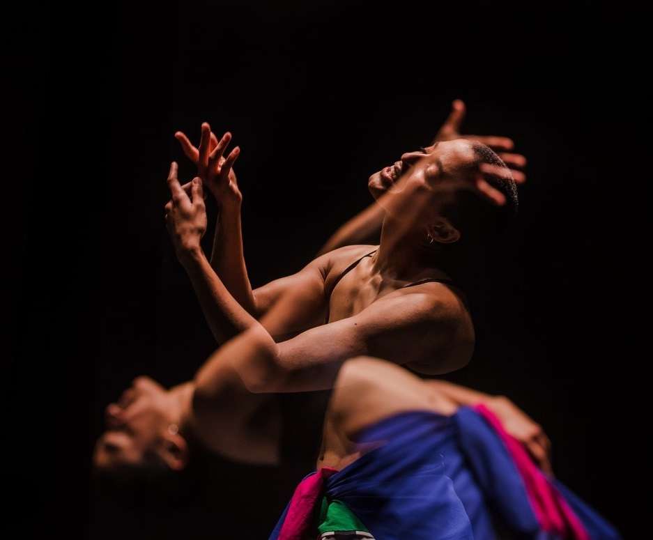 Photo de Nach, danseuse en brassière et jupe colorée en train de danser, le corps en arrière, effet de superposition de photos.