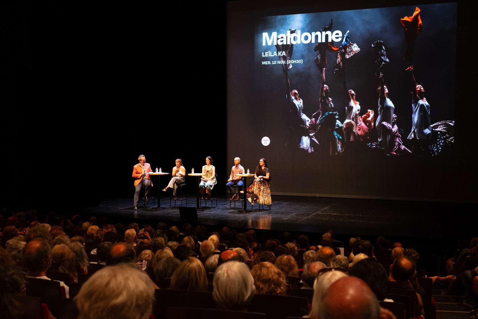 Photo de la salle Touchard comble avec sur scène cinq membres de l'équipe qui présentent le spectacle Maldonne lors de la présentation de saison. 