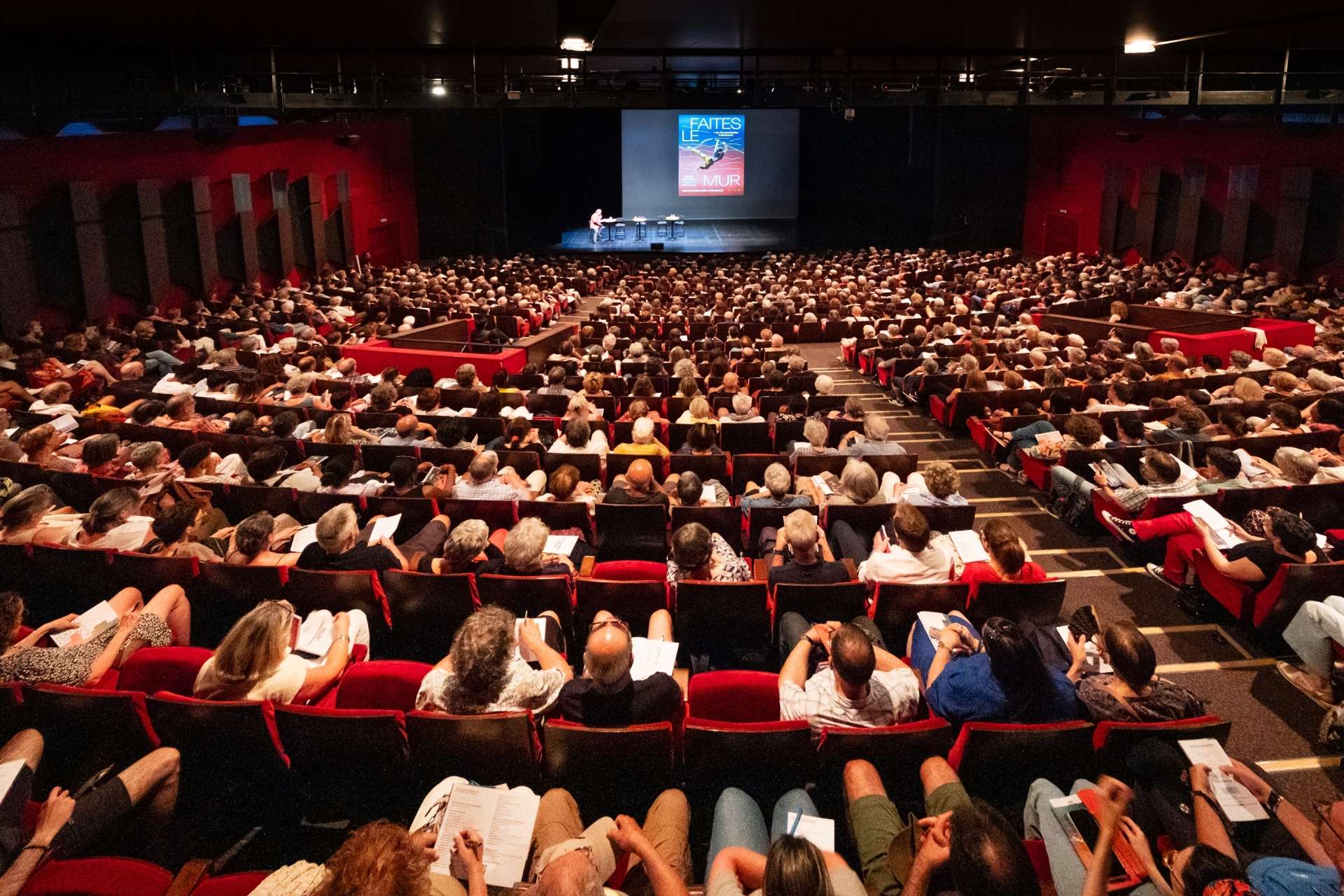 Photo de la salle vue de dos lors de la présentation de saison 25/26 : salle comble, public conquis !