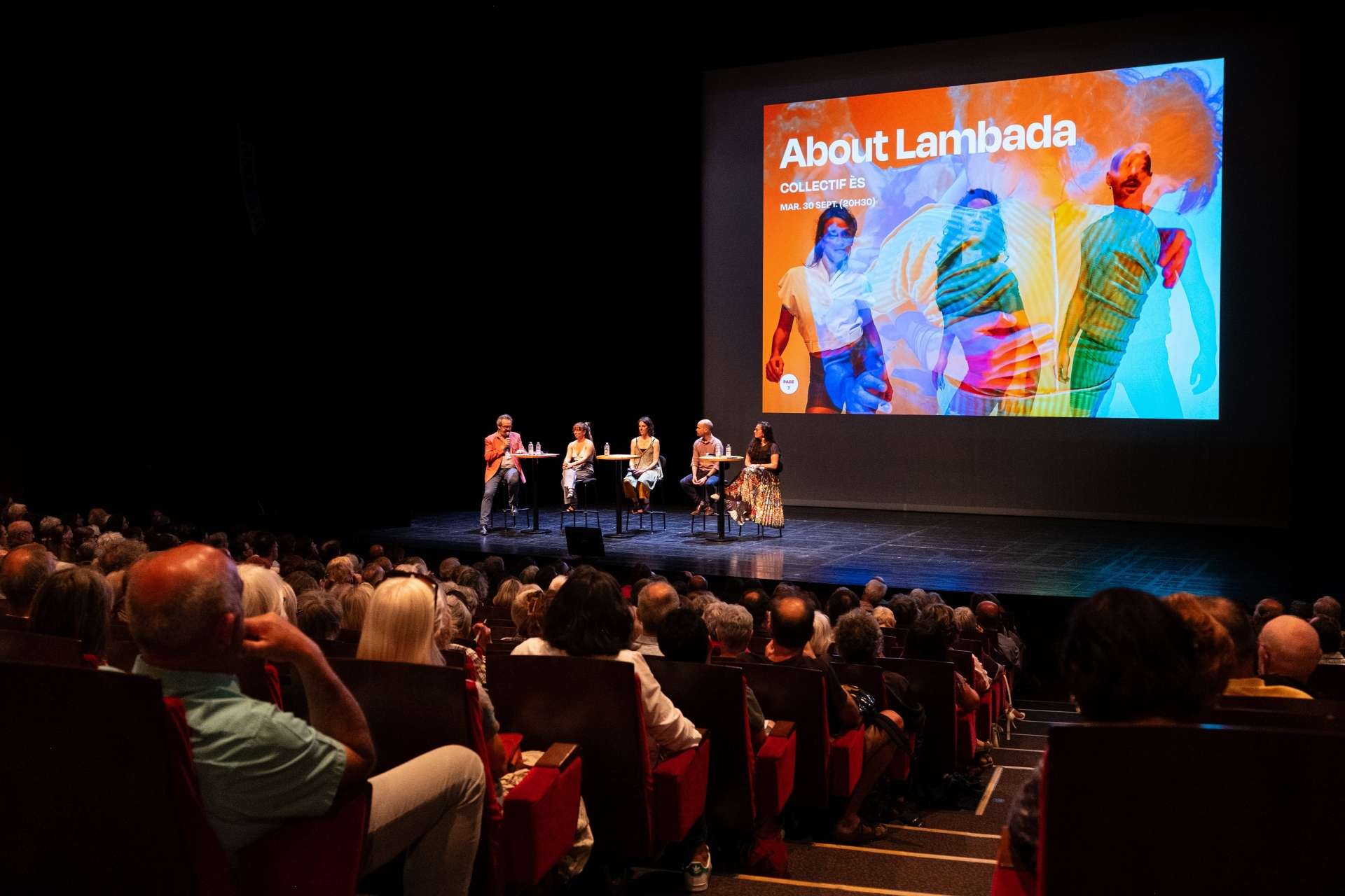 Photo de la salle Touchard comble avec sur scène cinq membres de l'équipe qui présentent le spectacle About lambada lors de la présentation de saison. 