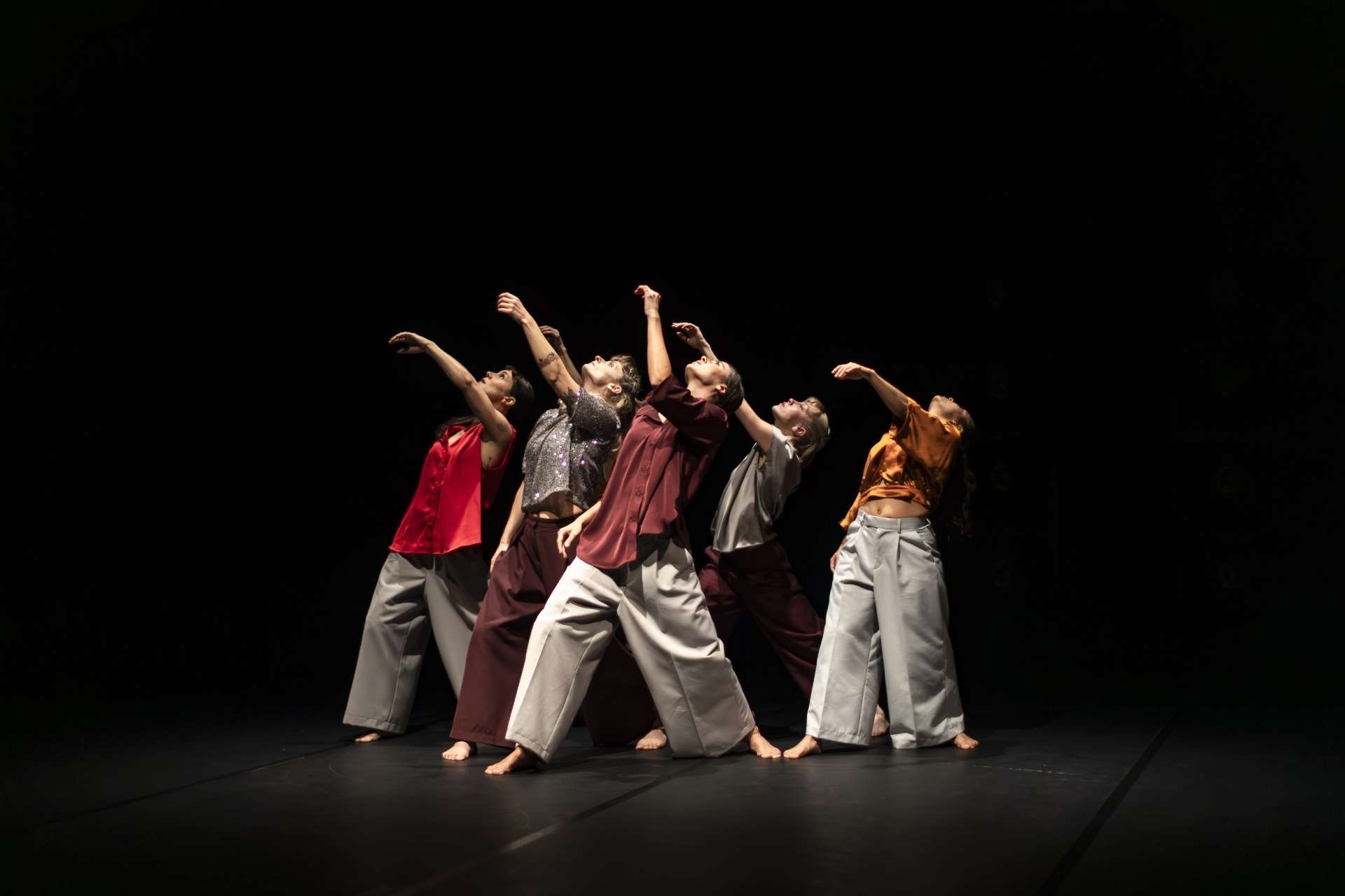 Six femmes forment un groupe et lèvent les bras en l'air en mode hip-hop. 