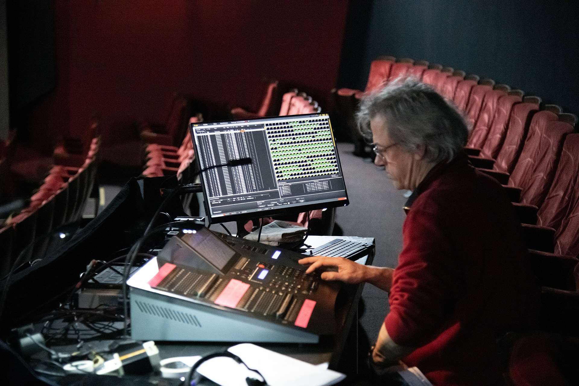 Technicien derrière sa console lumière.