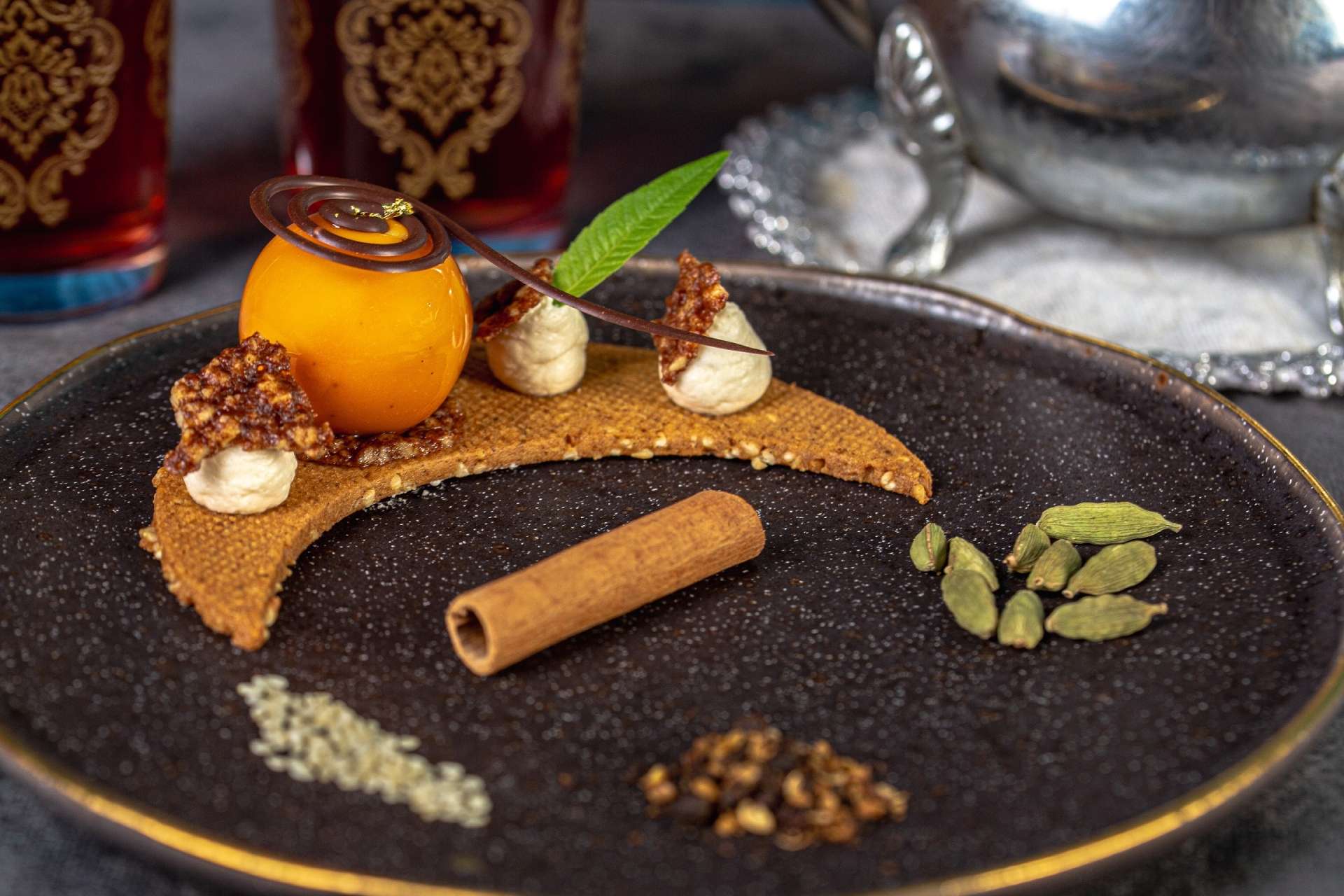 Gros plan et jolie présentation sur assiette noire de la pâtisserie La nuit orientale. 