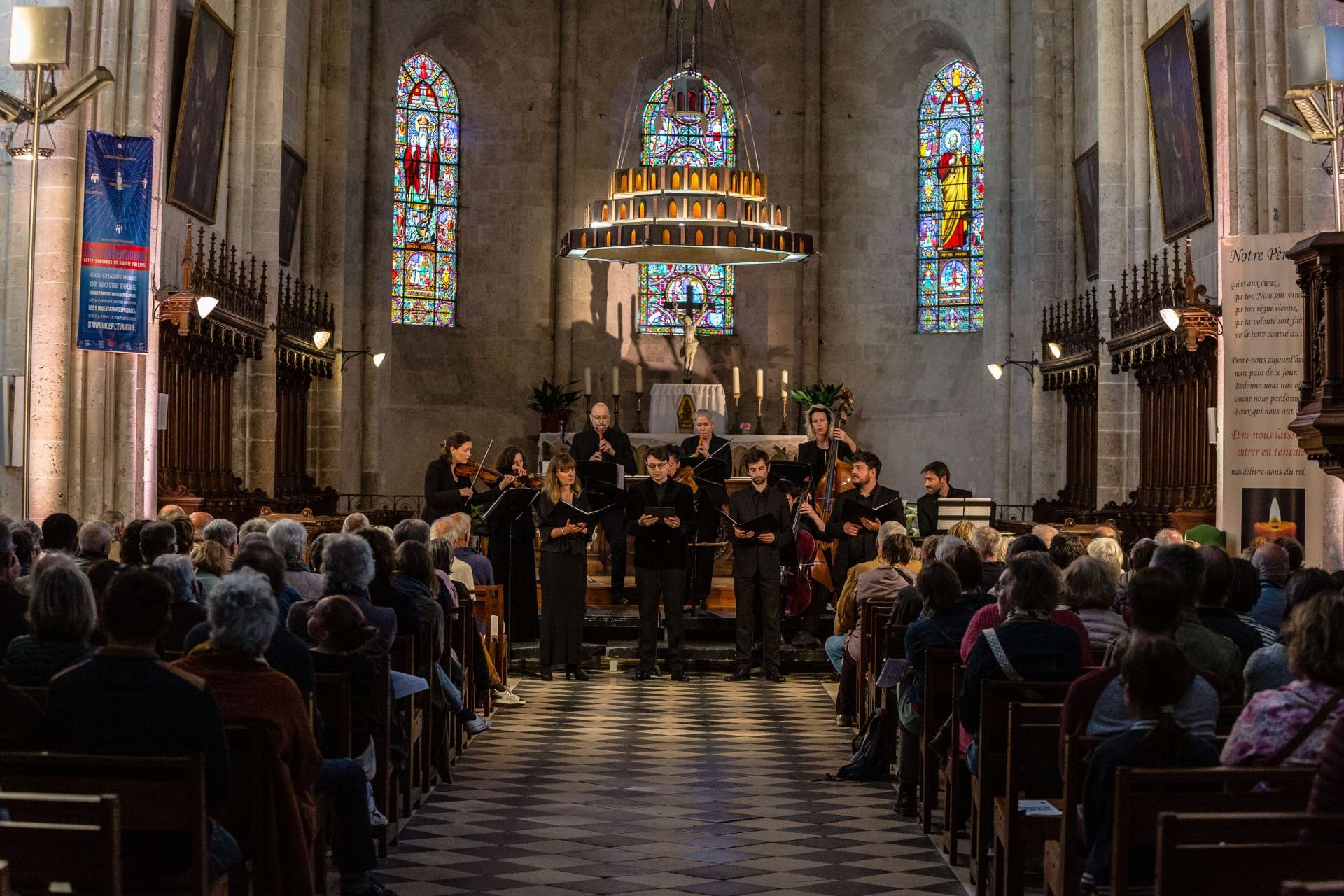 Photo de la représentation de l'ensemble de L'Escadron volant de la reine. Les artistes vues de face et le public de dos. 