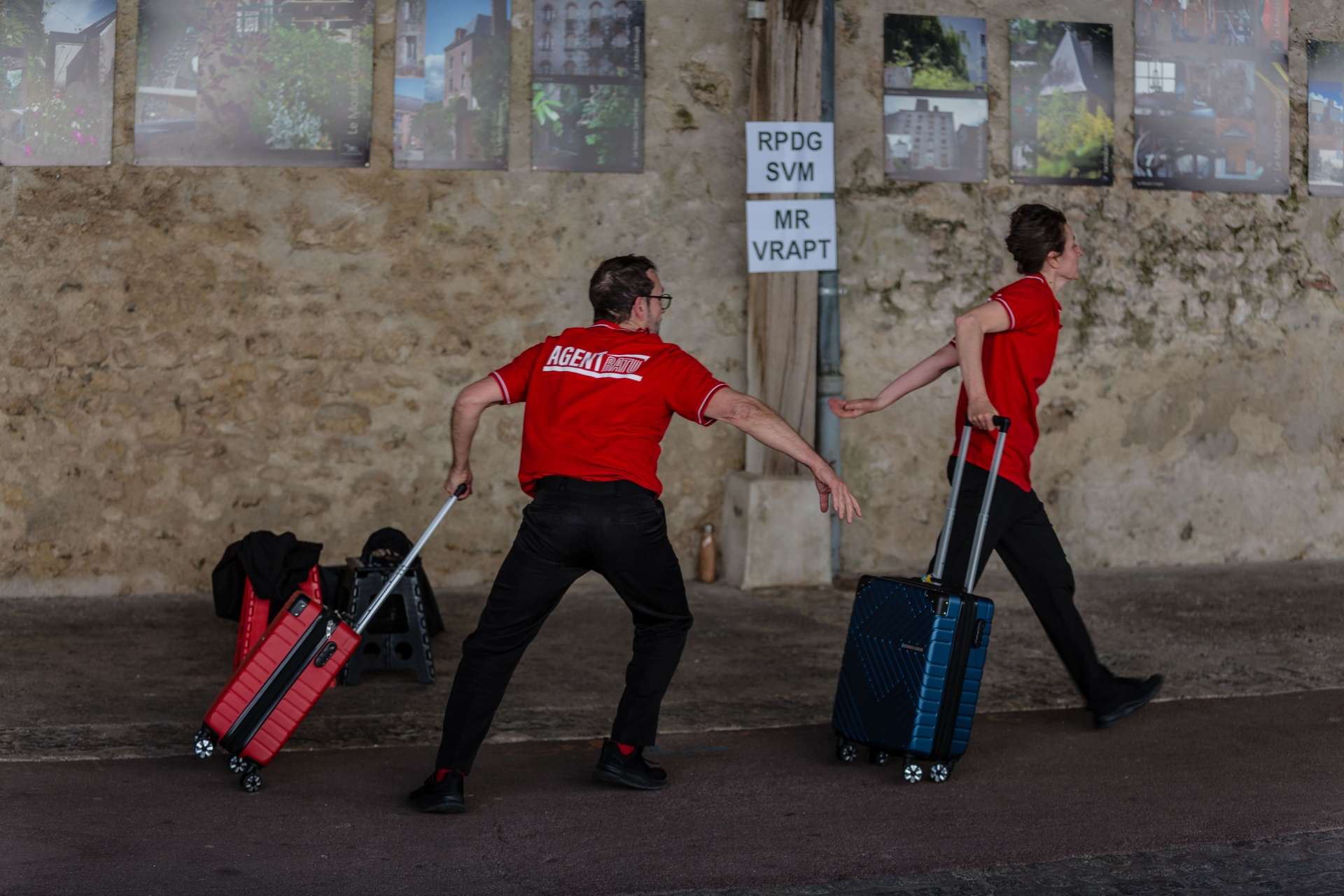Photo de la représentation de Sans crier gare. Les deux interprètes en pleine course un valise à la main. 